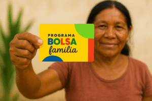 Pessoa segura cartão do Programa Bolsa Família em primeiro plano, representando o calendário do Bolsa Família.