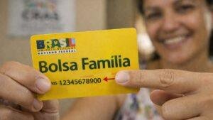 Pessoa apontando onde fica o número do NIS no cartão do Bolsa Família